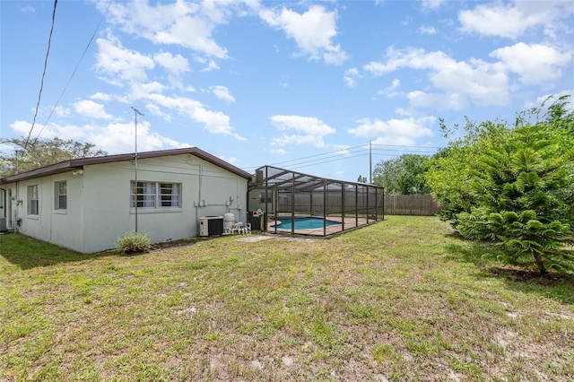 view of yard featuring central air condition unit, fence, a fenced in pool, and a lanai