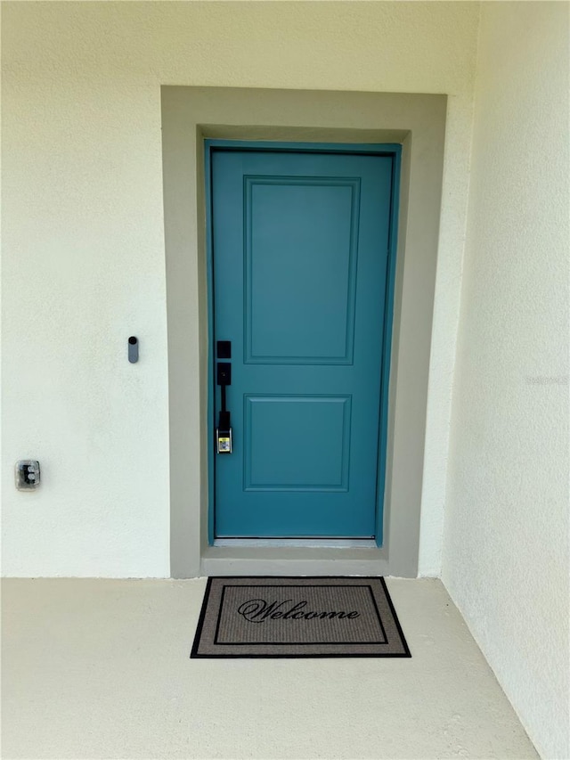 view of exterior entry with stucco siding