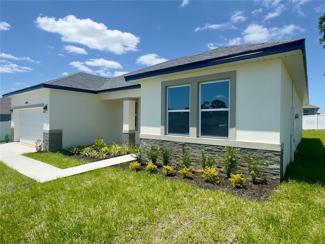 view of front facade featuring stucco siding, an attached garage, stone siding, and a front yard