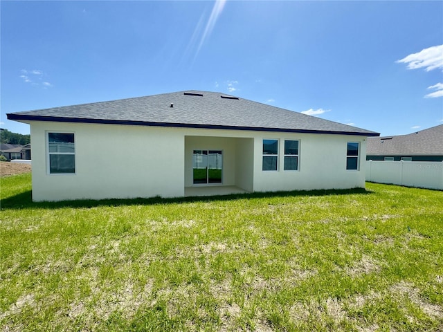 rear view of house with stucco siding and a shingled roof