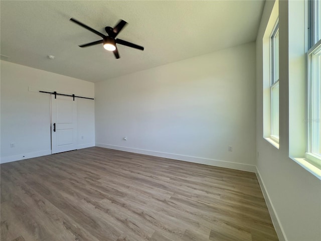 unfurnished bedroom featuring wood finished floors, baseboards, and a ceiling fan