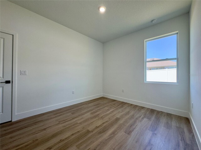 unfurnished room with wood finished floors and baseboards