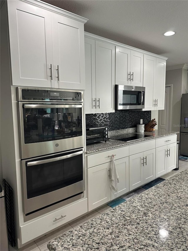 2137 Apian Way, Port Charlotte, FL 33953 - kitchen with black appliances, light stone countertops, white cabinets, tasteful backsplash, and crown molding