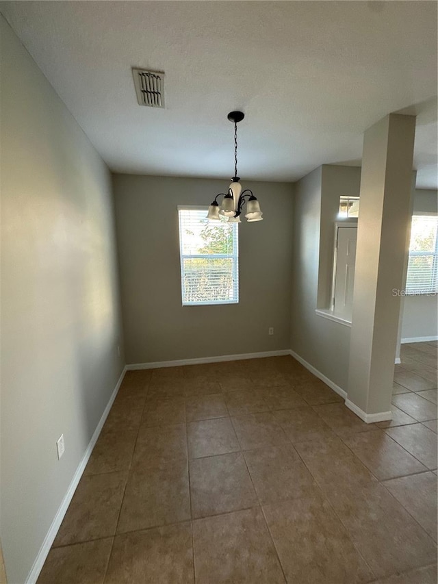 2125 Betsy Ross Ln, Saint Cloud, FL 34769 - unfurnished dining area with visible vents, tile patterned floors, an inviting chandelier, and baseboards