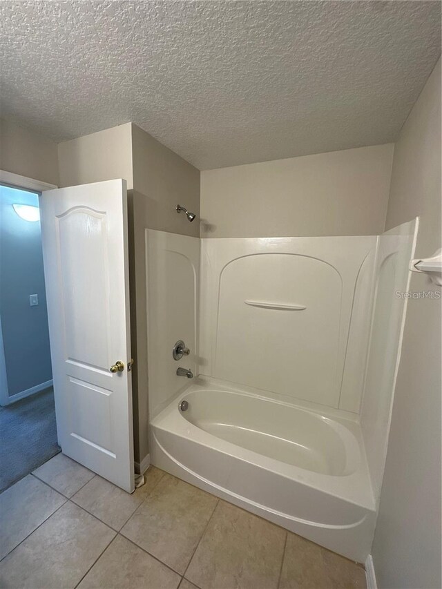 2125 Betsy Ross Ln, Saint Cloud, FL 34769 - bathroom featuring tile patterned flooring, a textured ceiling, baseboards, and shower / washtub combination