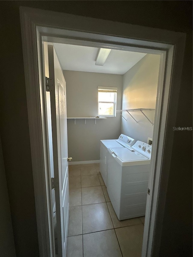 2125 Betsy Ross Ln, Saint Cloud, FL 34769 - clothes washing area with washing machine and clothes dryer, light tile patterned flooring, laundry area, and baseboards