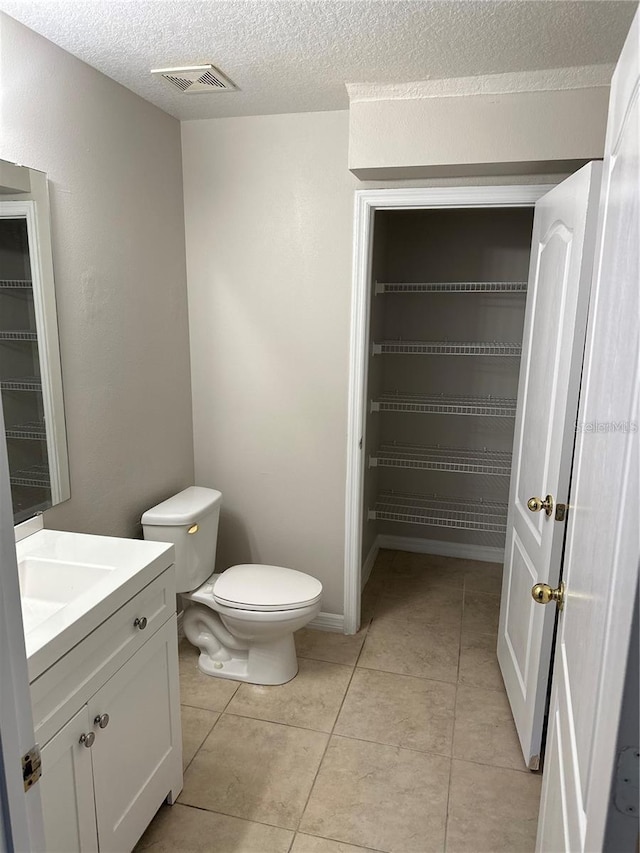 2125 Betsy Ross Ln, Saint Cloud, FL 34769 - bathroom with a textured ceiling, vanity, visible vents, toilet, and tile patterned floors