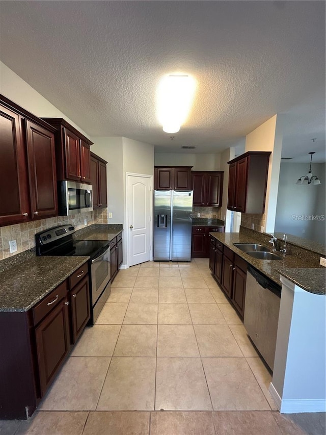 2125 Betsy Ross Ln, Saint Cloud, FL 34769 - kitchen featuring a textured ceiling, dark stone counters, decorative backsplash, stainless steel appliances, and a sink