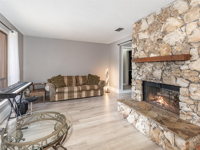 490 Burnt Tree Ln, Apopka, FL 32712 - living room with visible vents, wood finished floors, a fireplace, baseboards, and a textured ceiling