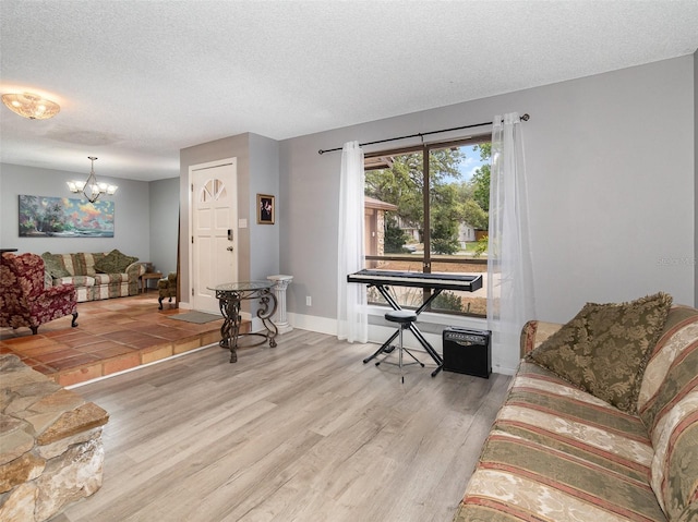 490 Burnt Tree Ln, Apopka, FL 32712 - living area featuring baseboards, a textured ceiling, a notable chandelier, and wood finished floors