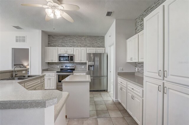 1900 NW 57th Ct, Ocala, FL 34482 - kitchen featuring stainless steel appliances, a center island, a sink, decorative backsplash, and a ceiling fan