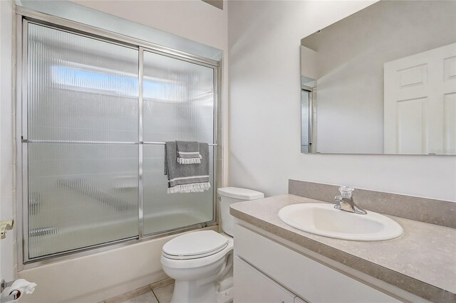 1900 NW 57th Ct, Ocala, FL 34482 - bathroom featuring toilet, vanity, enclosed tub / shower combo, and tile patterned flooring