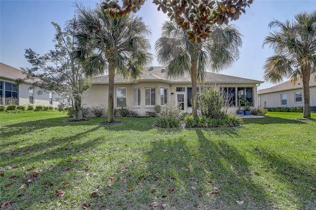 1900 NW 57th Ct, Ocala, FL 34482 - back of house featuring a yard, stucco siding, and a sunroom