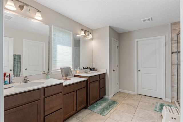 full bathroom featuring a tile shower, tile patterned floors, and visible vents