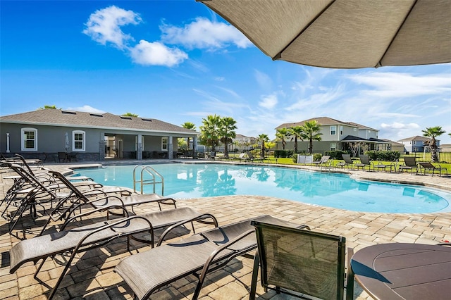 pool featuring a patio, a residential view, and fence
