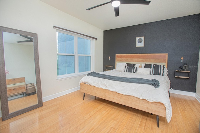 204 E S St Unit 2061, Orlando, FL 32801 - bedroom featuring baseboards, an accent wall, a ceiling fan, and wood finished floors