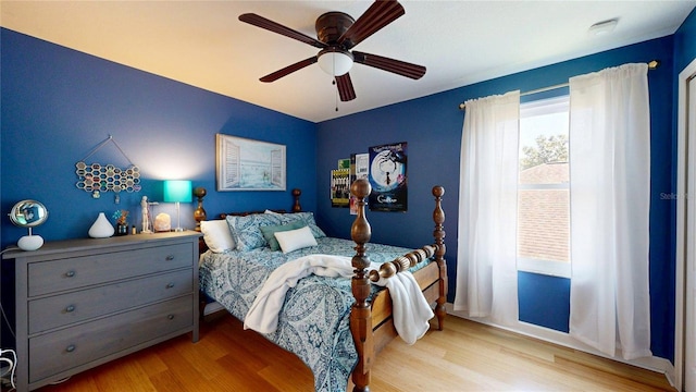 bedroom with wood finished floors, a ceiling fan, and baseboards