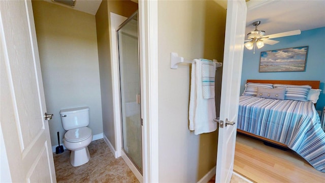 bathroom featuring a stall shower, toilet, and ceiling fan
