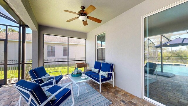 sunroom featuring ceiling fan, an outdoor hangout area, and plenty of natural light
