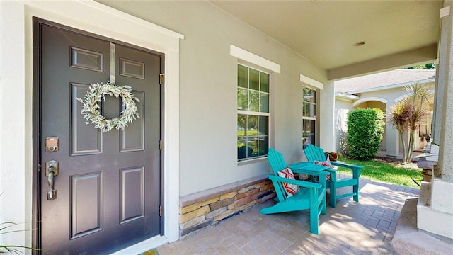 property entrance featuring stucco siding and a porch