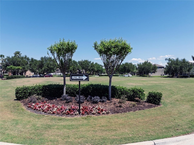 community / neighborhood sign featuring a yard