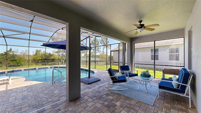 view of swimming pool with a patio, a ceiling fan, and glass enclosure