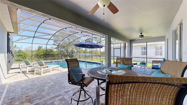 view of patio / terrace featuring a ceiling fan, an outdoor hangout area, and glass enclosure