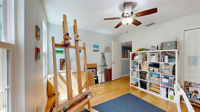 exercise room featuring a ceiling fan and wood finished floors