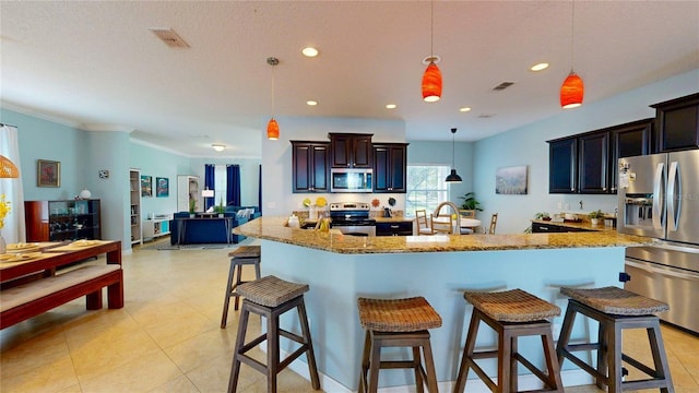 kitchen featuring appliances with stainless steel finishes, a breakfast bar, a large island, pendant lighting, and crown molding
