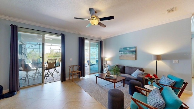 living area with a ceiling fan, crown molding, baseboards, light tile patterned flooring, and a textured ceiling