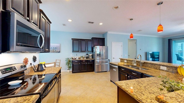 kitchen with appliances with stainless steel finishes, a sink, dark brown cabinets, hanging light fixtures, and ornamental molding