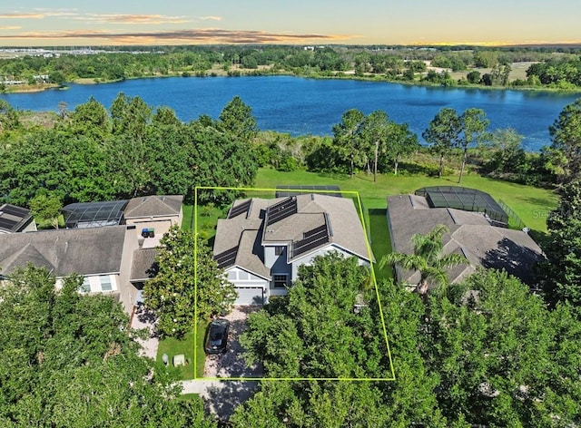 aerial view of property's location featuring property parcel outlined, a nearby body of water, and a tree filled landscape