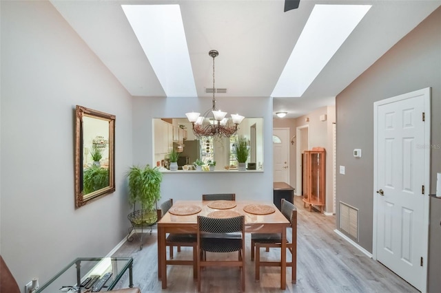 dining room featuring an inviting chandelier, baseboards, light wood-style flooring, and visible vents