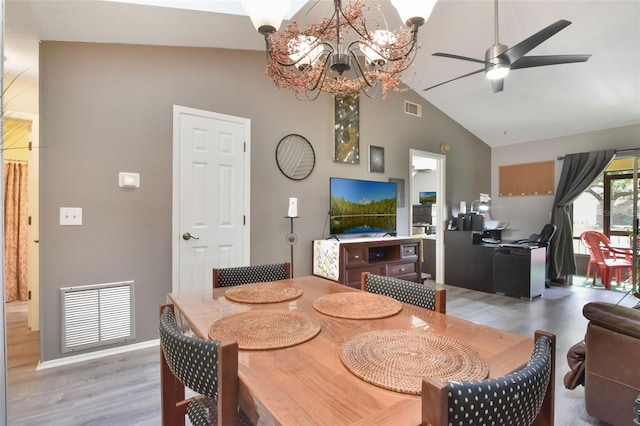 dining space featuring high vaulted ceiling, visible vents, ceiling fan with notable chandelier, and light wood-type flooring