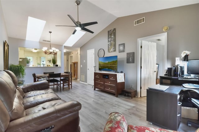 living area with high vaulted ceiling, ceiling fan with notable chandelier, wood finished floors, and visible vents