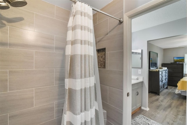 bathroom featuring vanity, tiled shower, and wood finished floors