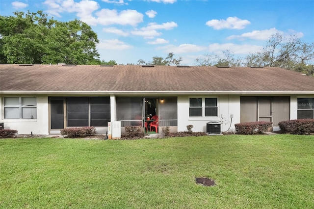 back of property with a shingled roof, a yard, and cooling unit