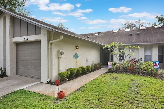 view of front of property featuring an attached garage, a front lawn, stucco siding, and driveway