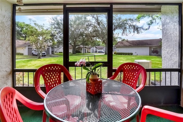 sunroom featuring a residential view and outdoor dining area
