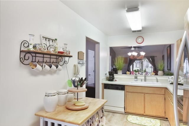 kitchen with dishwasher, a sink, light countertops, light wood-style floors, and light brown cabinets