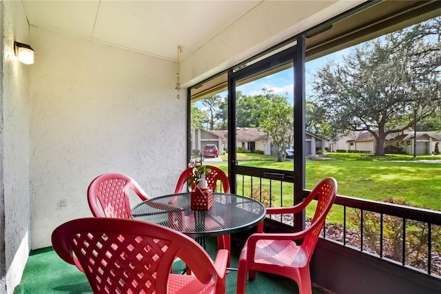 sunroom / solarium featuring a residential view and outdoor dining area
