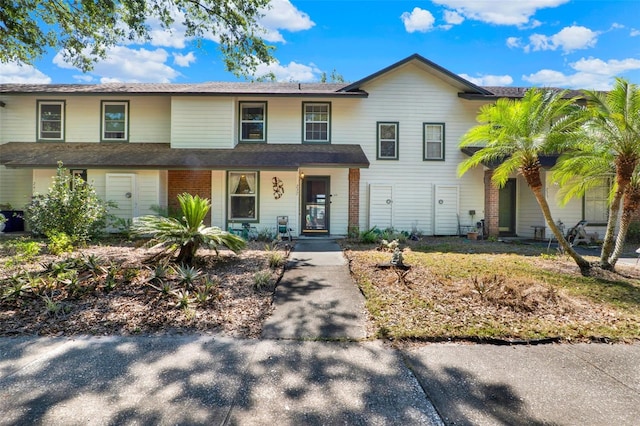 townhome / multi-family property featuring a porch and a shingled roof