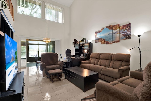 living area with a notable chandelier, a high ceiling, light tile patterned flooring, and a wealth of natural light