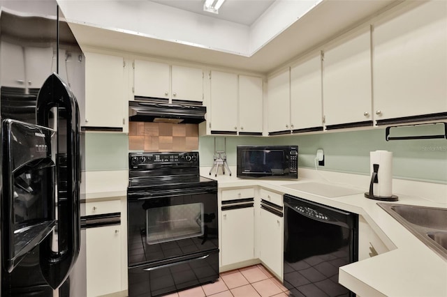 kitchen with light countertops, light tile patterned floors, under cabinet range hood, and black appliances