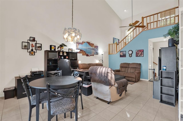 dining area with high vaulted ceiling, stairway, ceiling fan with notable chandelier, light tile patterned floors, and baseboards