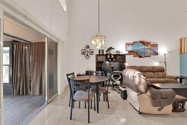 dining room featuring light tile patterned flooring, a high ceiling, and a notable chandelier