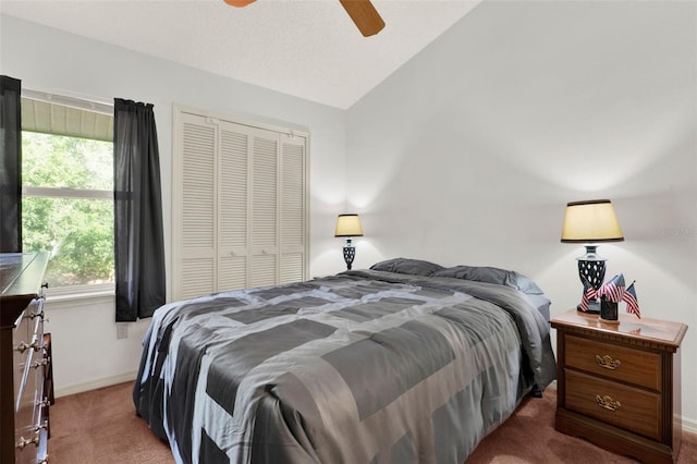 bedroom with vaulted ceiling, a ceiling fan, a closet, baseboards, and carpet flooring