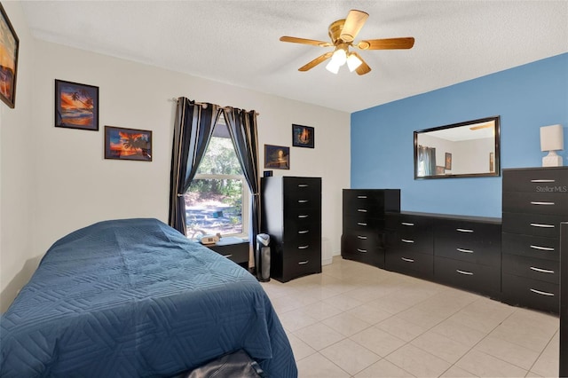 bedroom with a textured ceiling, a ceiling fan, and light tile patterned floors