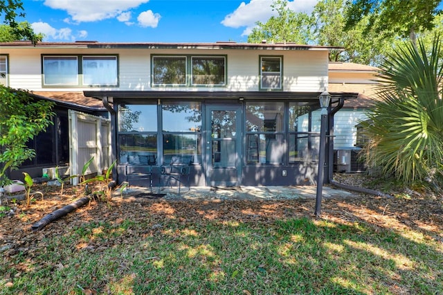 back of property with a sunroom and central AC