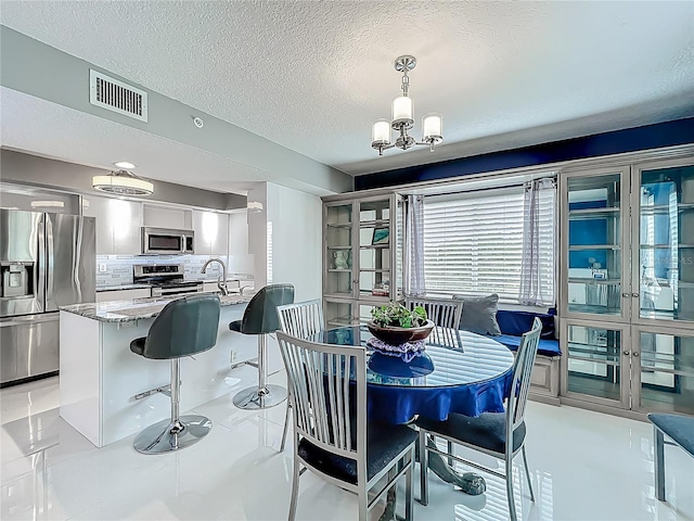 1150 Carmel Cir Unit 301, Casselberry, FL 32707 - dining area with visible vents, an inviting chandelier, and a textured ceiling